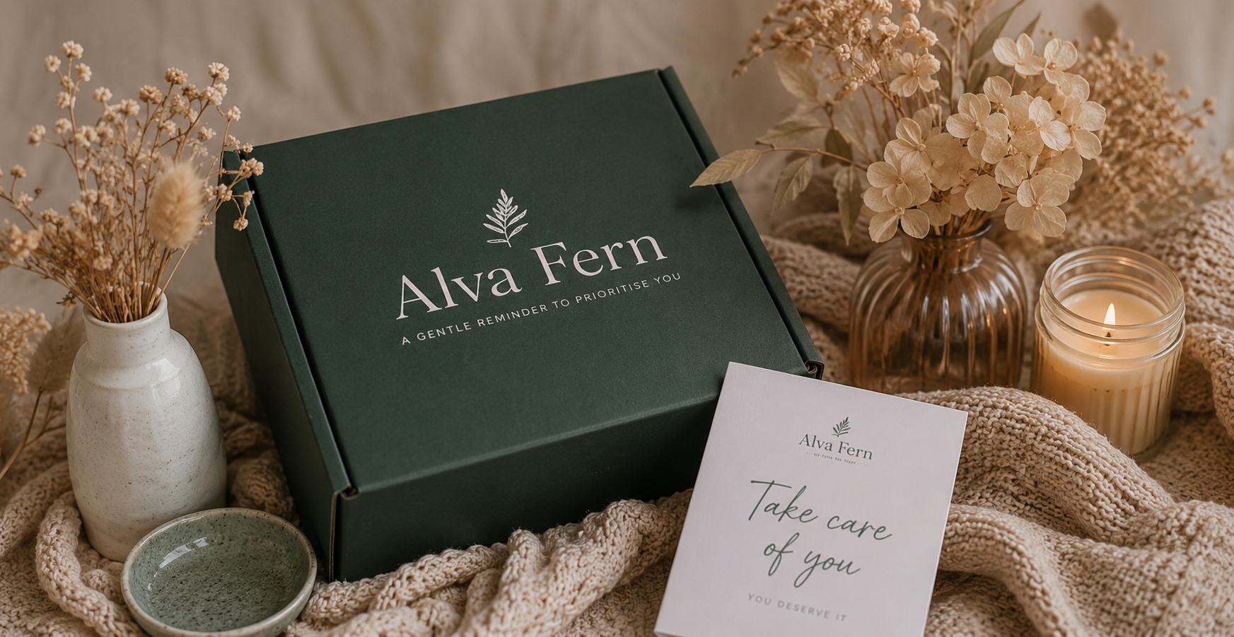Alva Fern self-care subscription box surrounded by dried flowers, a candle and a Take care of you card